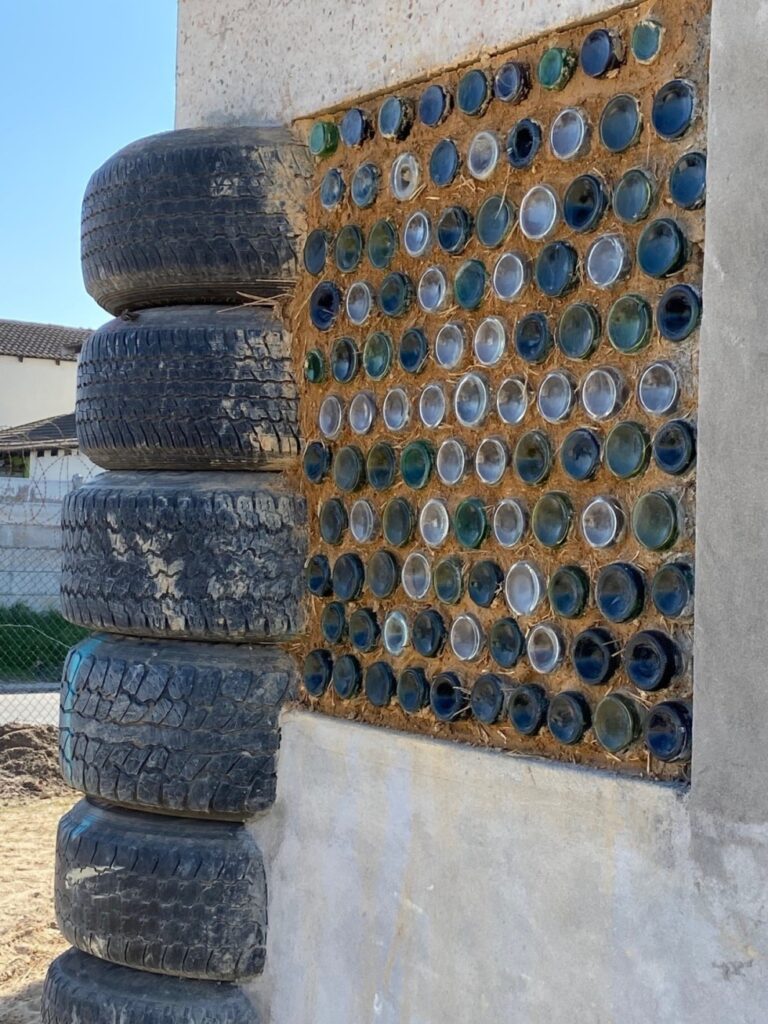 Flasker og bildæk benyttet som byggemateriale i township i Sydafrika