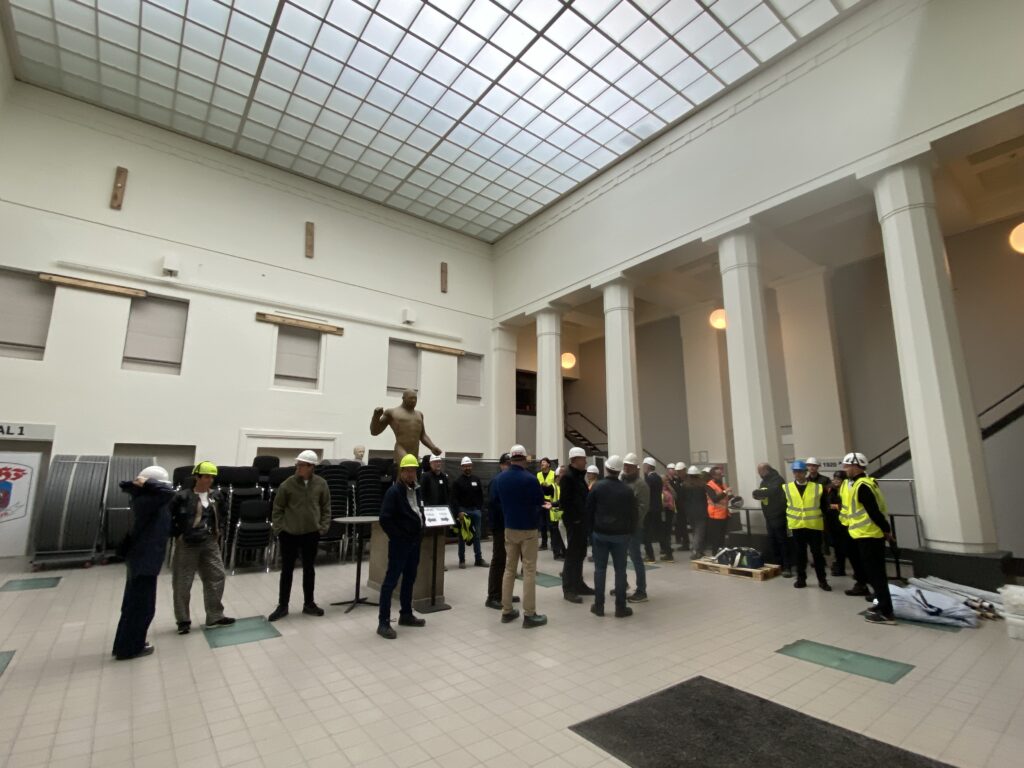 Gruppe ser op på hvide buer og glasfacade, Kongelunden Aarhus